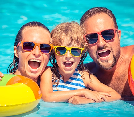 Gelukkige familie spelen in zwembad. Zomervakantie concept